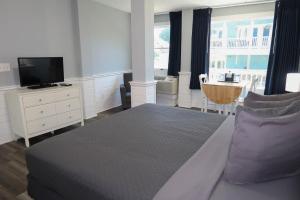 1 dormitorio con 1 cama con almohadas moradas y TV en The Inn at Corolla en Corolla