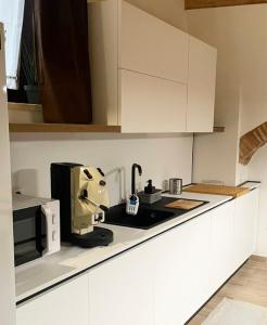 a kitchen with white cabinets and aounter at La Buona Volta in Montalbano Ionico +14 photos