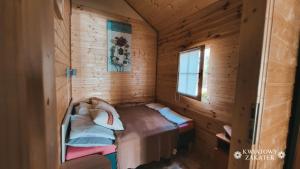 ミエルノにあるMielno - Kwiatowy Zakątek #2の木造キャビン内のベッド1台が備わる小さな客室です。