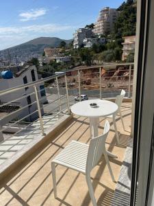 a white table and chairs on a balcony with a view at Vanesa Rooms in Sarandë