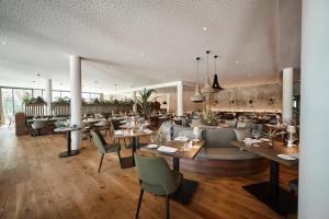 um restaurante com mesas e cadeiras num quarto em Nouri em Bad Krozingen
