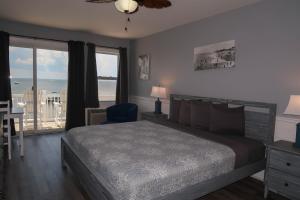 The Inn at Corolla في كورولا: غرفة نوم مع سرير وإطلالة على المحيط