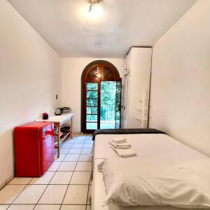 a bedroom with a red refrigerator and a desk at Coliving Stela Mares in Florianópolis