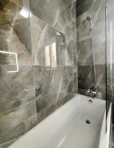 a bathroom with a white tub and a mirror at Al-Andalus, Chic Central Rooms in Victoria +15 photos