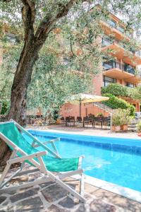 托里德爾貝納科的住宿－維蘭德住宅酒店，一个带椅子和一棵树的游泳池以及一座建筑