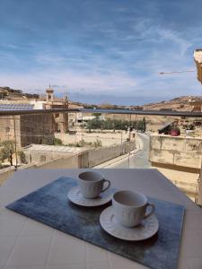 two coffee cups sitting on a table with a view at Al-Andalus, Chic Central Rooms in Victoria