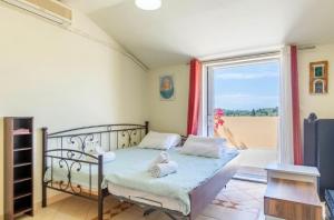 a bedroom with a bed and a large window at La Soffitta di Bampina in Perivolion