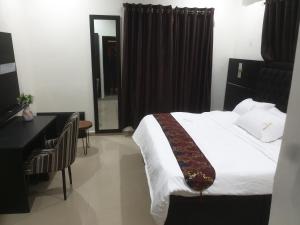 a hotel room with a bed and a desk and a desk at Downunder suites in Gwarinpa