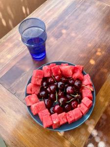 a plate of fruit on a table with a drink at Riad Zouhour in Marrakech