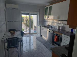 a kitchen with white cabinets and a table with a tableablish at Vivenda Cordeiro in Bárrio