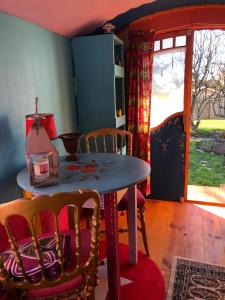 a dining room with a table and chairs and a window at La roulotte de Nath in Cousance