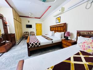 Habitación de hotel con 2 camas y TV en Lexus Lodge en Islamabad