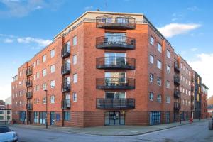 a red brick building with balconies on a street at Exquisite City Centre Apartment - 2 Bed 2 Bath - Free Parking - Netflix Amazon Disney Enabled Smart TV in Birmingham