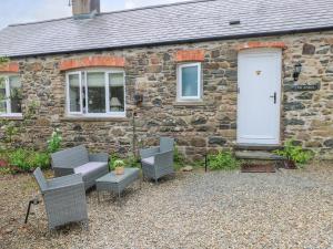 a stone house with chairs and a white door at The Stables in Haverfordwest