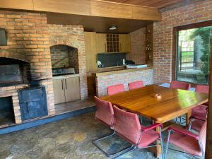 a kitchen with a wooden table and a brick fireplace at The Hill House in Prizren