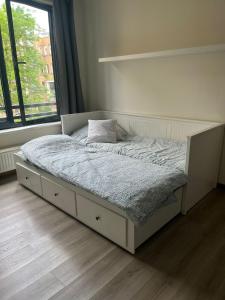 un lit blanc dans une chambre avec une fenêtre dans l'établissement Coeur de Bruxelles, Grand-Place et Mannekenpiss, à Bruxelles