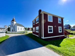 a small house with a church and a street at Trinity Suites in Trinity