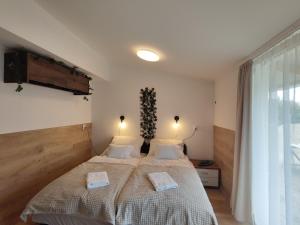 um quarto com uma cama com duas toalhas em Sweety-Apartman em Mátészalka
