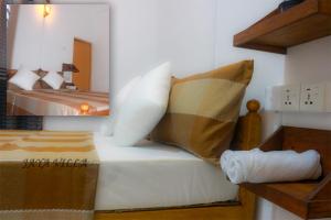 um quarto com uma cama com almofadas em Jaya Villa em Negombo