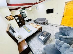 sala de estar con 1 cama y 2 sillas en Lexus Lodge en Islamabad