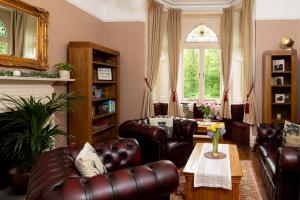 sala de estar con muebles de cuero y ventana en Coalbrookdale Villa en Ironbridge