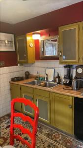 una cocina con fregadero y una silla roja. en Cozy room near Airport & Highway en St. Louis