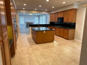 cocina grande con armarios de madera y encimeras negras en ALE Displaced, Relocation, Insurance, Fire, Flood, en Corona