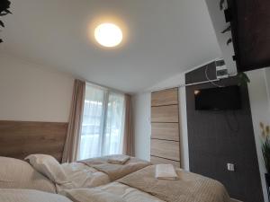 um quarto com duas camas e uma televisão na parede em Sweety-Apartman em Mátészalka