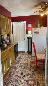 uma cozinha com um frigorífico branco e uma parede vermelha em Cozy room near Airport & Highway em Saint Louis