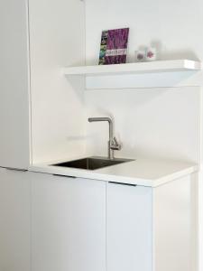 a kitchen with a sink and white cabinets at Heide Apartments in Schneverdingen