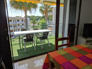 Habitación con balcón con mesa y sillas. en Reus Mediterrani, en Cambrils
