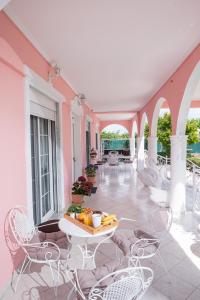 a patio with chairs and a table with fruit on it at Villa Regina By The Sea in Epanomi