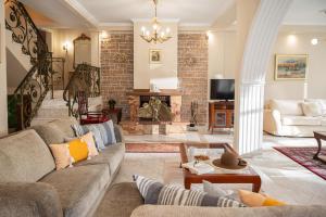 a living room with a couch and a fireplace at Villa Regina By The Sea in Epanomi