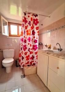 e bagno con servizi igienici e tenda doccia con fiori. di Gaia Estate a Calimno (Kalymnos) Altre 20 foto