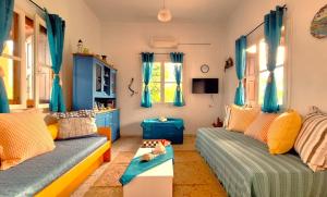 a living room with two beds and blue curtains at Gaia Estate in Kalymnos