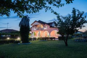 a house with a tree in the yard at Villa Regina By The Sea in Epanomi