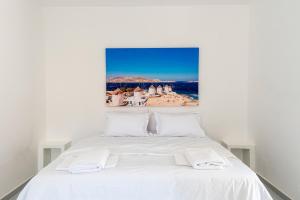 a white bed with white sheets and pillows at Be Kythnos in Mérikhas