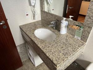 a bathroom counter with a sink and a mirror at Flat Particular no Comfort Suites in Brasilia +36 photos