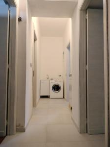 a hallway with a washing machine in a white room at Sunny House in Parghelia