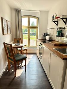 a kitchen with a table and a chair and a sink at Ferienwohnung Bress in Ueckermünde