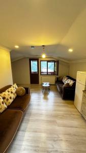 a living room with two couches and a table at Maneviga Cafe & Apart in Uzungol
