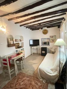 sala de estar con cama y escritorio en Casa Miguelito en Comares