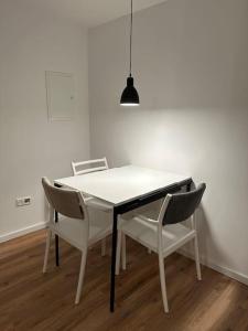 einen Esstisch mit 2 Stühlen und einer Lampe in der Unterkunft 4Betten mit KücheWaschmaschine in Duisburg