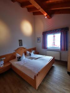 een slaapkamer met een groot bed en een groot raam bij Gästehaus Thaler in Mittelberg