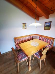 drewniany stół jadalny z krzesłami i lampką w obiekcie Gästehaus Thaler w mieście Mittelberg