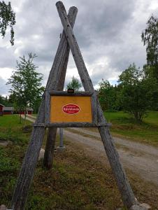 um sinal de madeira na berma de uma estrada em ,,Björklunda" cozy apartment in swedish lapland em Lycksele