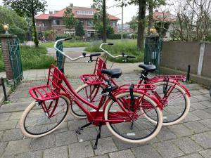 dos motos rojas estacionadas una al lado de la otra en Plato by Hofstad Studio’s en Scheveningen