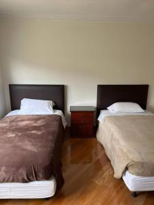 dos camas sentadas una al lado de la otra en un dormitorio en Departamento Amplio En El Centro De Otavalo en Otavalo