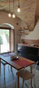 a kitchen with a wooden table with chairs and a dining room at Appartamento di Porta Maggiore in Cupra Marittima +8 photos