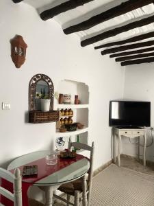 a dining room with a table and a tv at Casa Miguelito in Comares